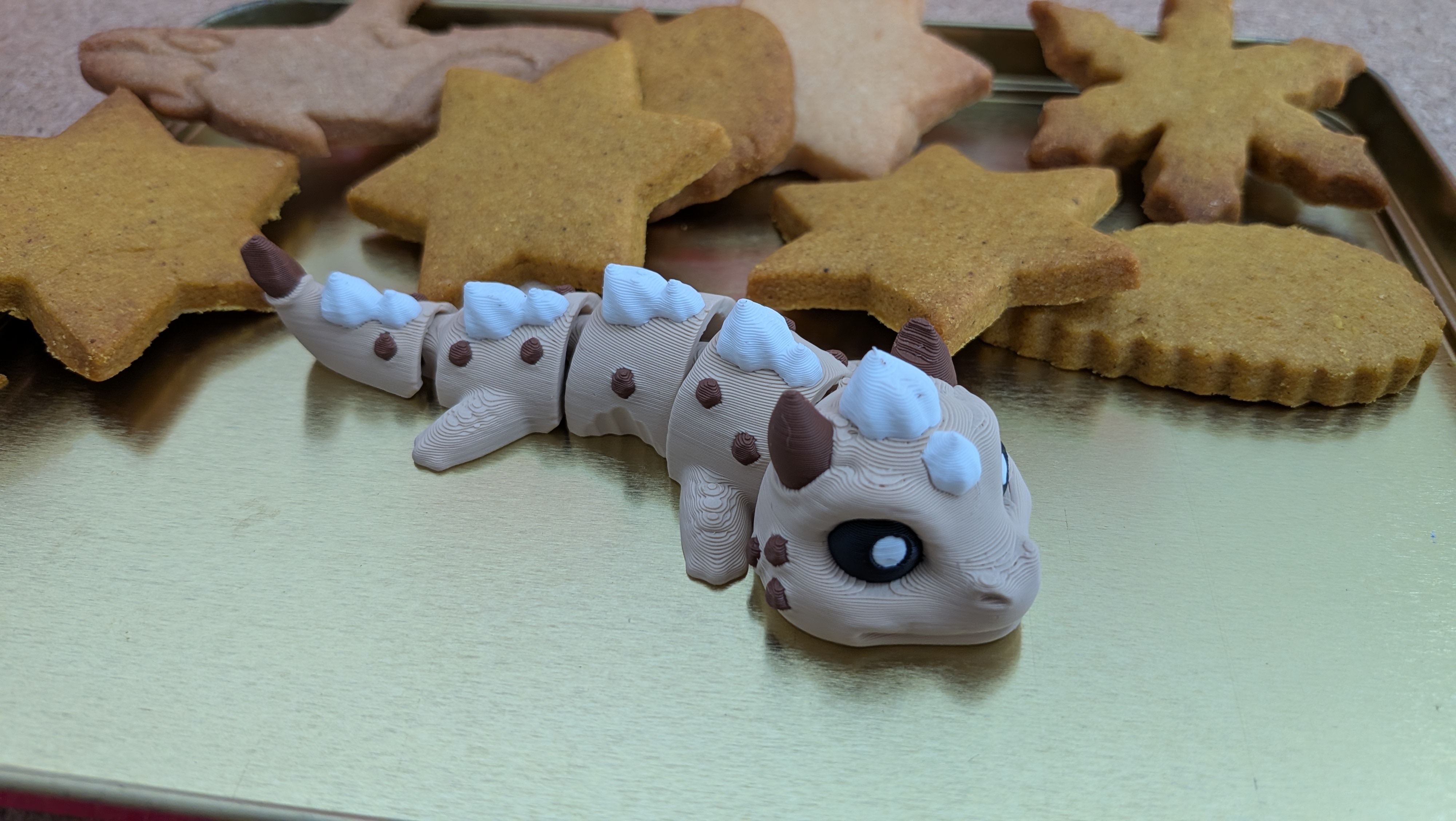 Cookie Dragon articulated keychain figure in front of cookies