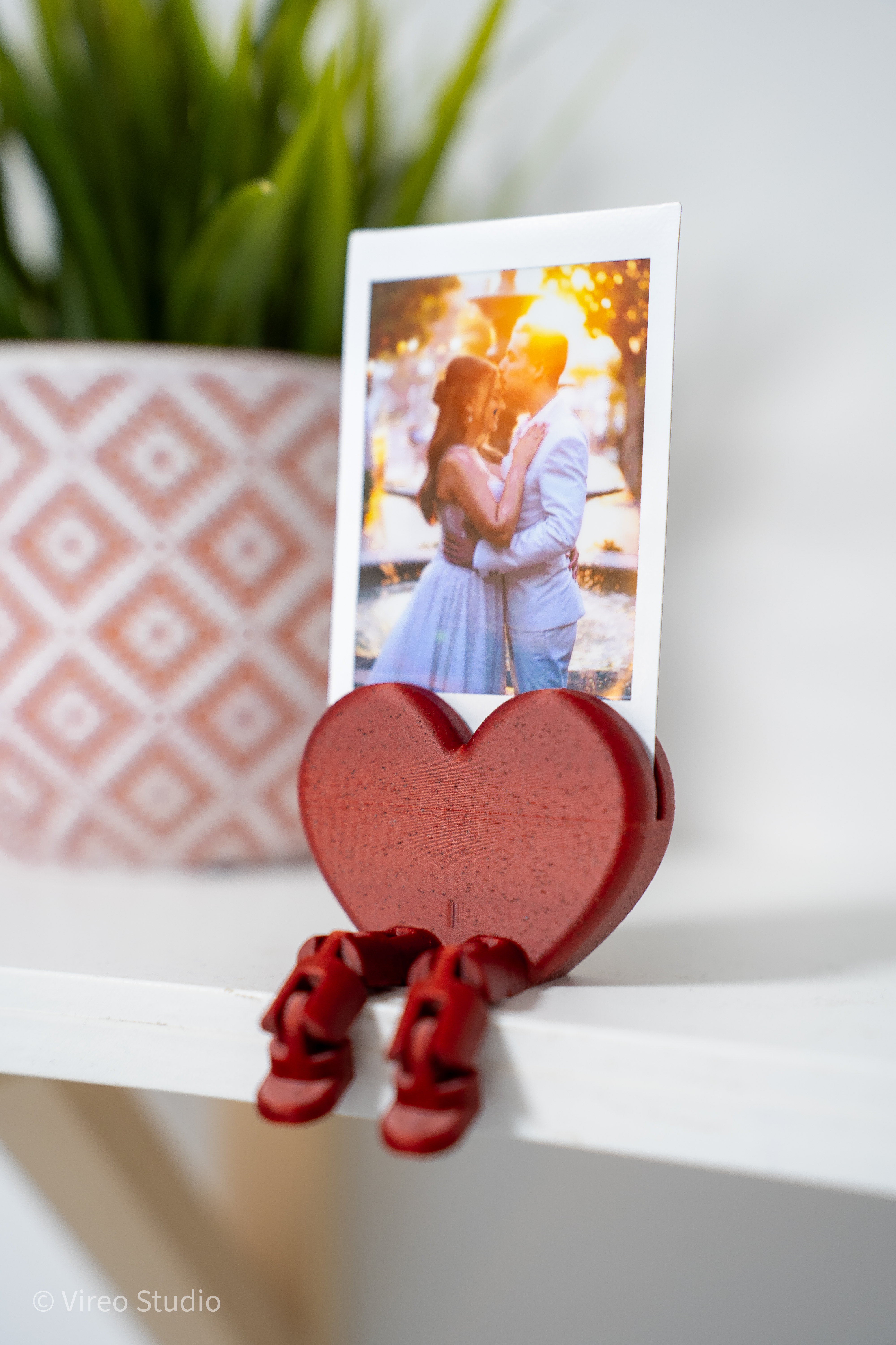Heart photo and card display with flexible legs holding a printed photo